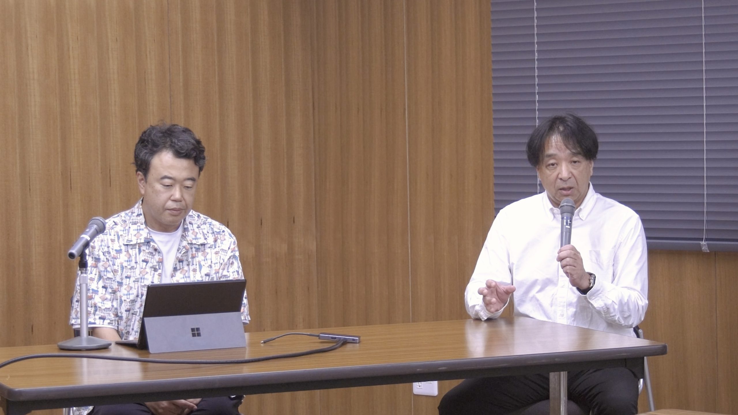 講評を聞く井上准教授と講評を行う田上教授の写真。真剣な雰囲気。
